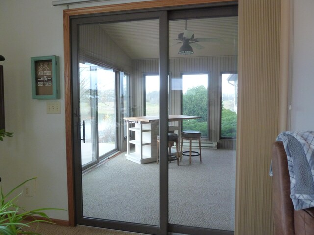 entryway with carpet flooring, baseboard heating, vaulted ceiling, and ceiling fan