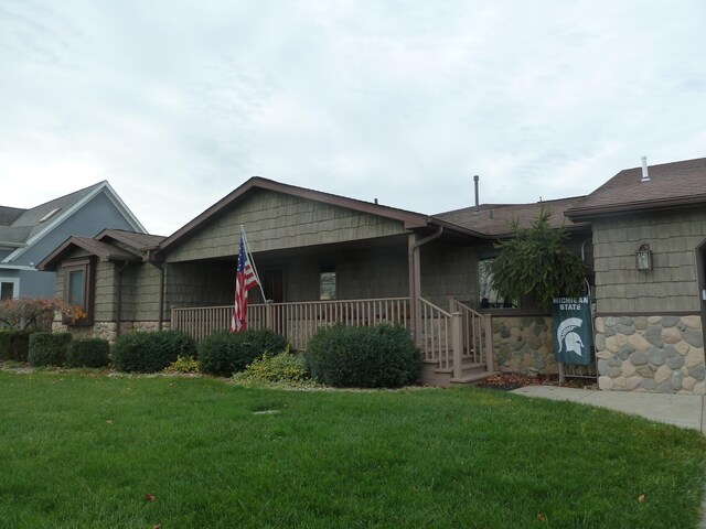 single story home with a porch and a front lawn