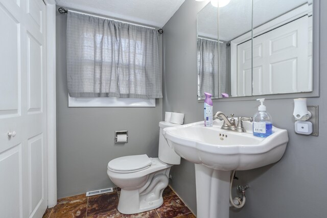 bathroom with a textured ceiling and toilet