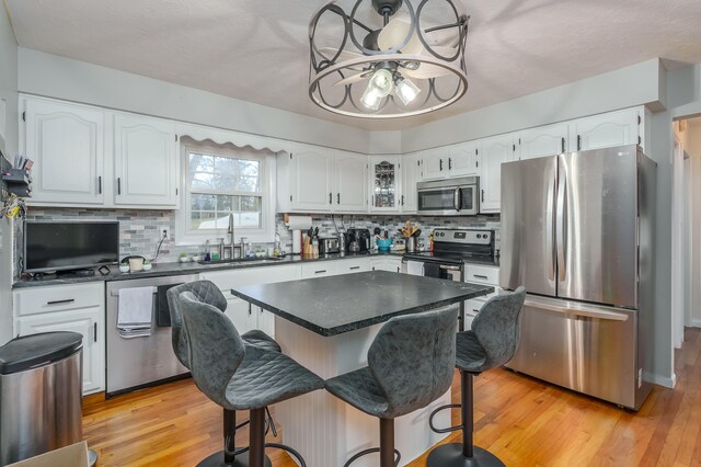 kitchen with sink, white cabinets, stainless steel appliances, and light wood-type flooring