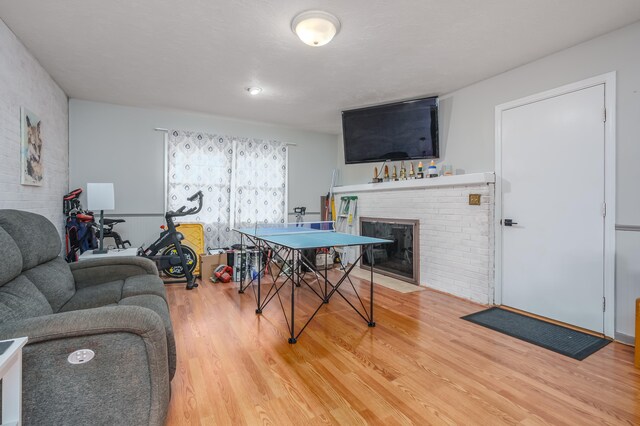 playroom with a fireplace and wood-type flooring