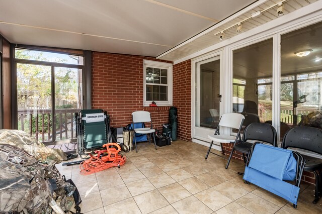 sunroom / solarium featuring track lighting