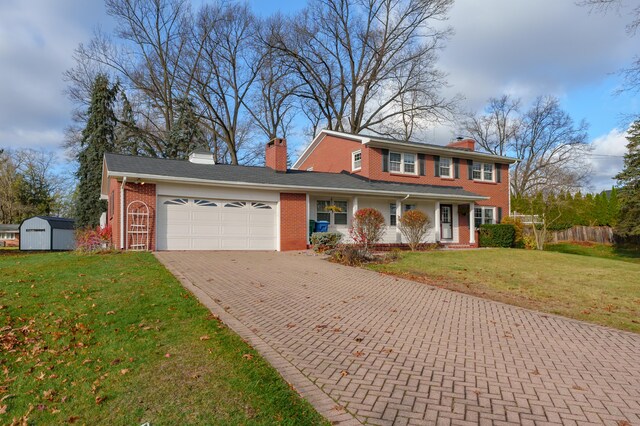 view of front of home featuring a storage unit, a garage, and a front lawn