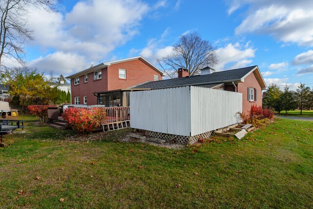 view of property exterior with a wooden deck and a yard