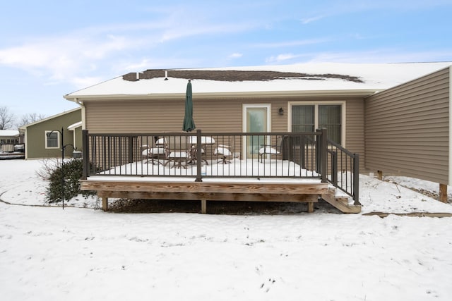 view of snow covered back of property