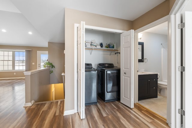 laundry area with washer and dryer, dark wood-type flooring, and sink