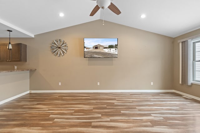 interior space featuring ceiling fan, light hardwood / wood-style flooring, and vaulted ceiling