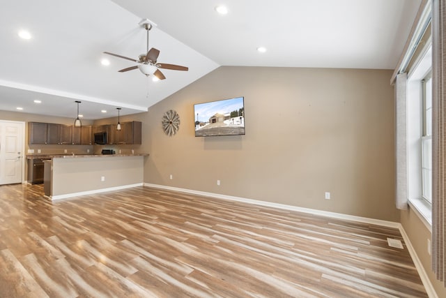 unfurnished living room with plenty of natural light, light hardwood / wood-style floors, lofted ceiling, and ceiling fan