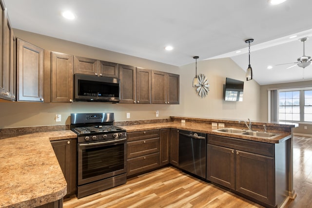 kitchen featuring kitchen peninsula, sink, lofted ceiling, and appliances with stainless steel finishes