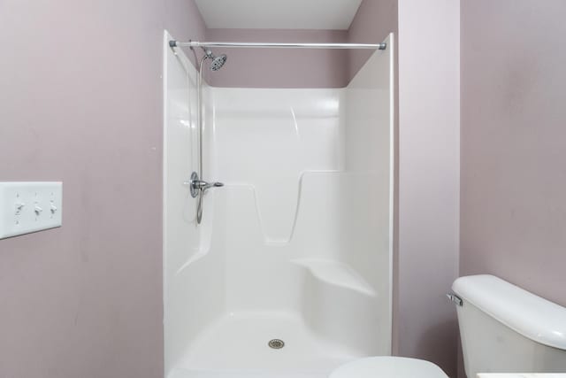 bathroom featuring a shower and toilet