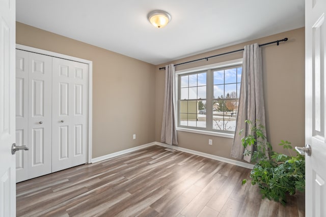 unfurnished bedroom with wood-type flooring and a closet