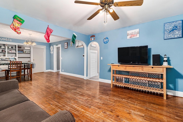 living room featuring wood-type flooring and ceiling fan with notable chandelier