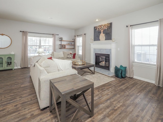 living room with a tile fireplace and dark hardwood / wood-style flooring