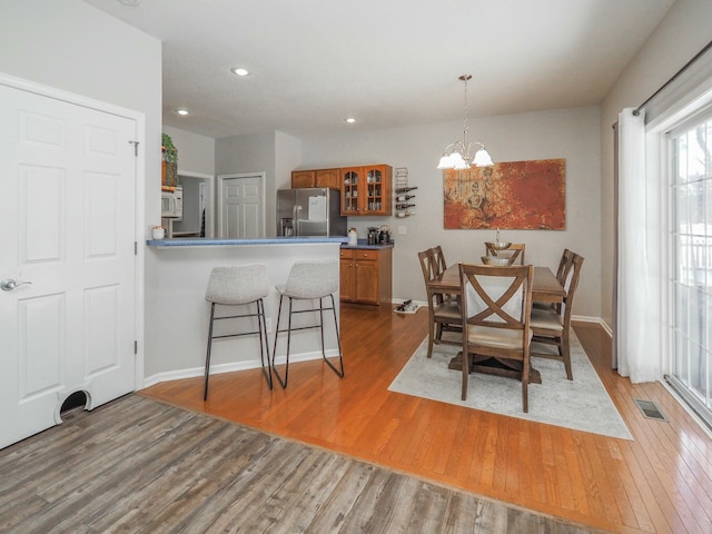 dining area with wood-type flooring and a chandelier