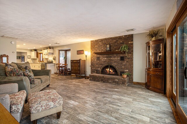 living room featuring a fireplace, hardwood / wood-style floors, and a textured ceiling