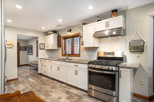 kitchen featuring light stone countertops, sink, stainless steel appliances, hardwood / wood-style floors, and white cabinets