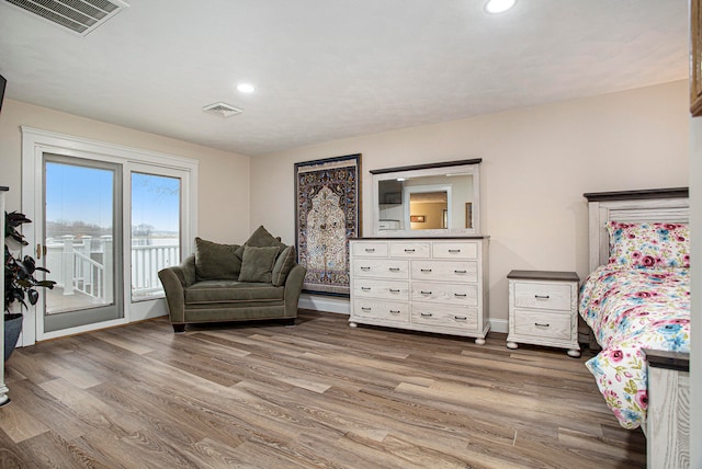 bedroom with access to exterior and hardwood / wood-style floors