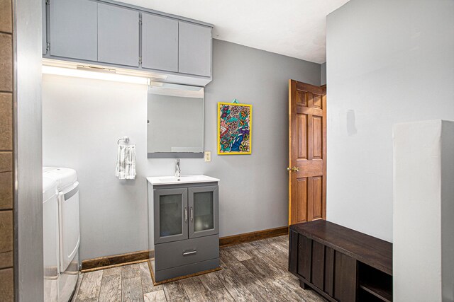 bathroom featuring wood-type flooring, vanity, and washer and clothes dryer