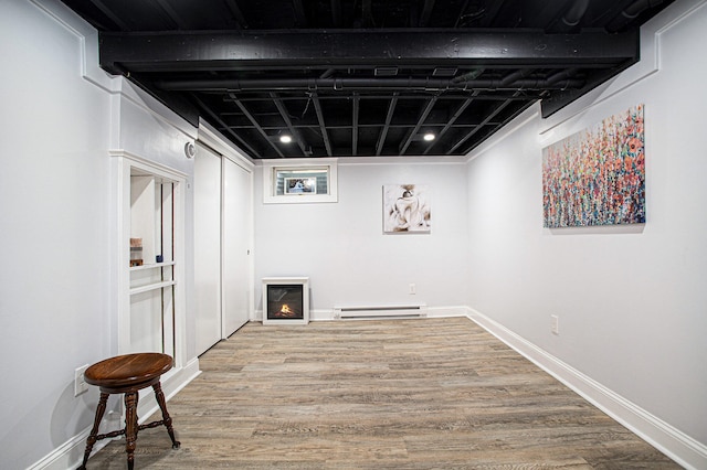 basement with a baseboard radiator and wood-type flooring