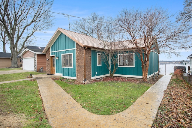 view of front of home featuring a front yard, a water view, and a garage