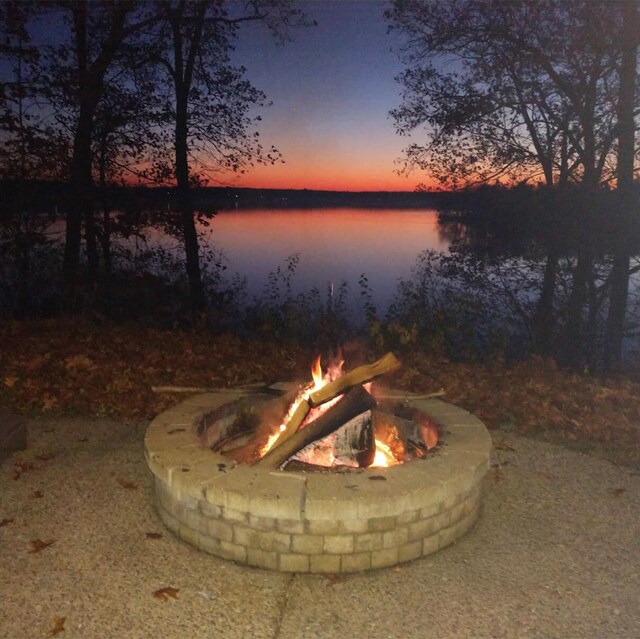 exterior space featuring a water view and a fire pit