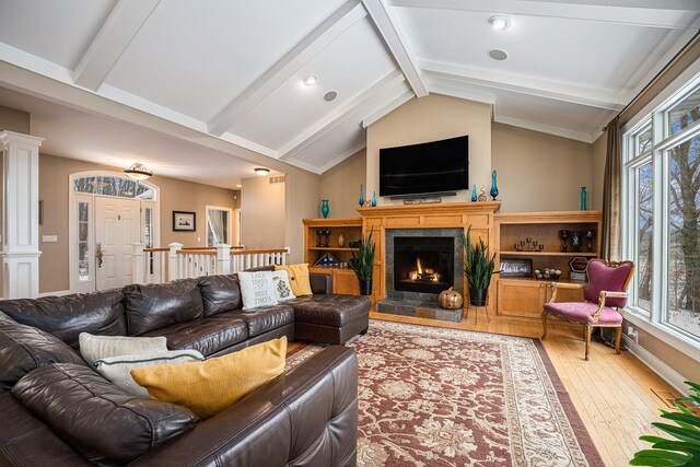 living room with lofted ceiling with beams and light hardwood / wood-style floors