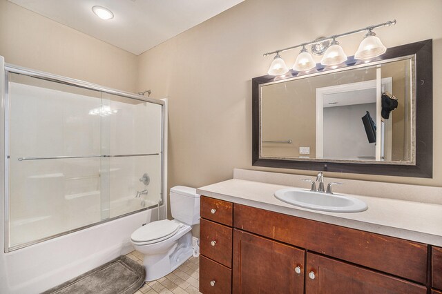 full bathroom with tile patterned floors, toilet, combined bath / shower with glass door, and vanity