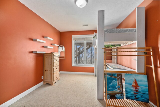 interior space with light carpet, a textured ceiling, and vaulted ceiling