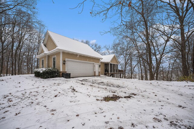 view of snowy exterior with a garage