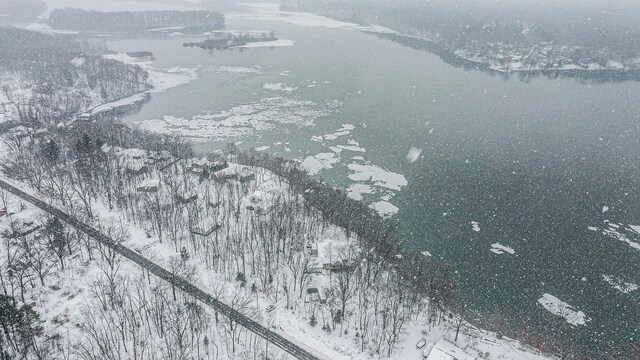 snowy aerial view featuring a water view