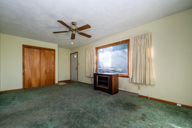 unfurnished living room featuring baseboard heating, dark carpet, and ceiling fan