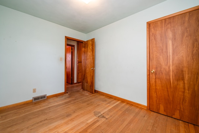 unfurnished bedroom featuring a closet and light wood-type flooring