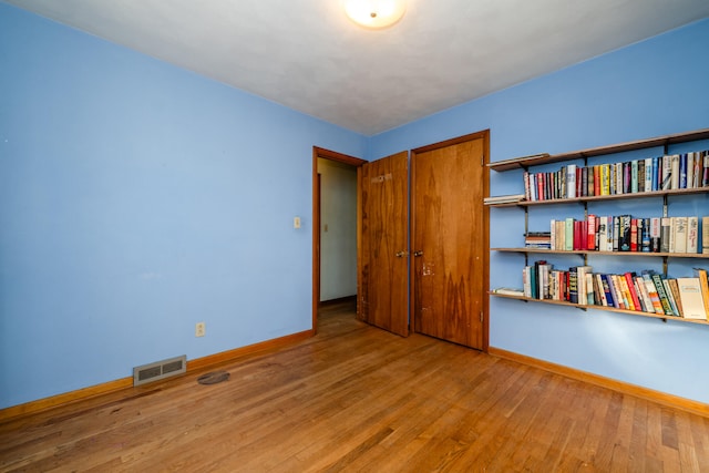 unfurnished bedroom with hardwood / wood-style floors and a closet