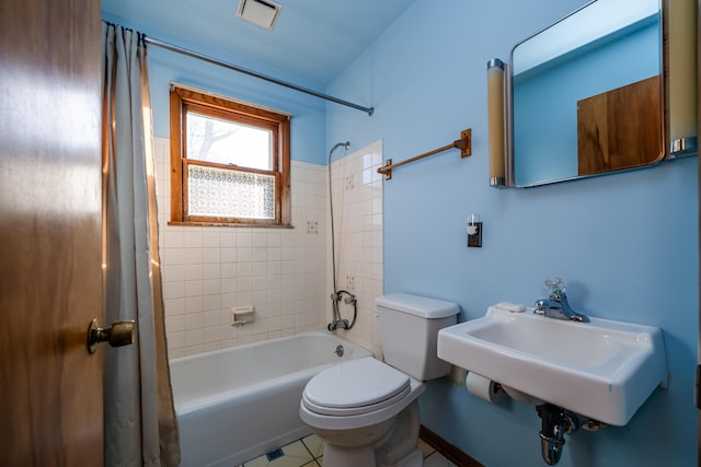 full bathroom featuring sink, toilet, tile patterned flooring, and tiled shower / bath