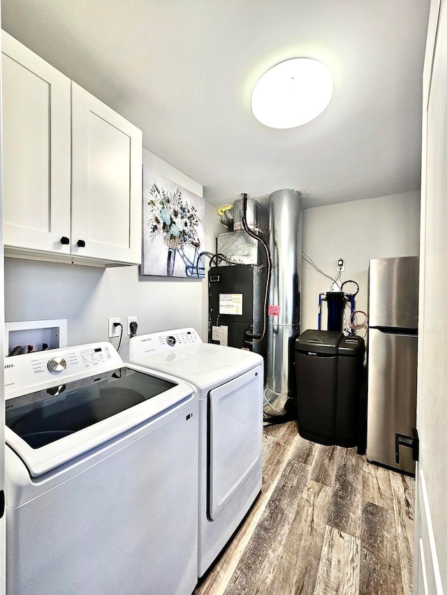 laundry area featuring cabinets, wood-type flooring, and washer and clothes dryer