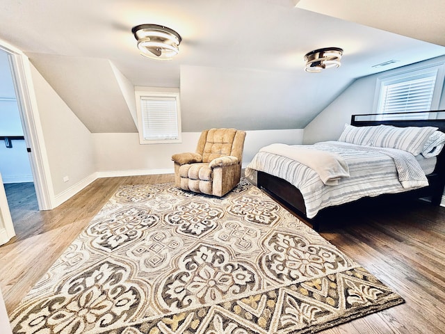 bedroom featuring light hardwood / wood-style floors and lofted ceiling