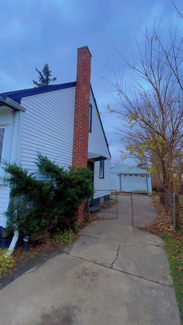 view of property exterior with a garage and an outdoor structure