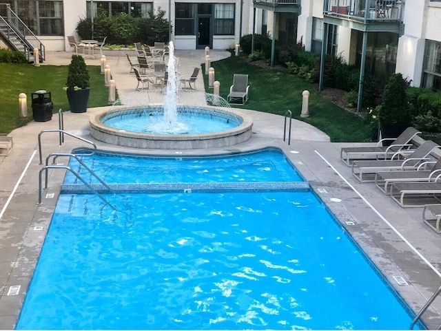 view of pool featuring a community hot tub and a patio area