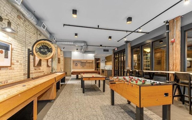 game room featuring carpet floors and brick wall