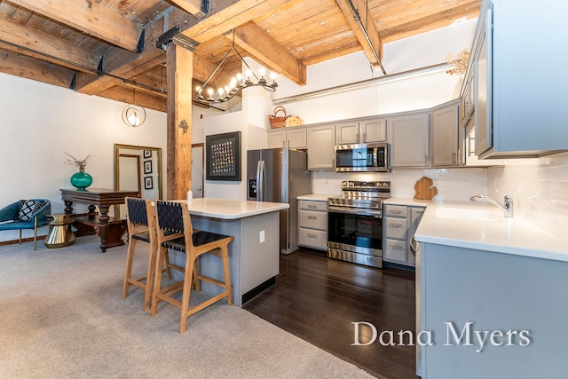 kitchen with pendant lighting, sink, a kitchen island, dark hardwood / wood-style flooring, and stainless steel appliances