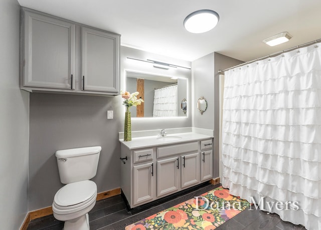 bathroom featuring walk in shower, toilet, vanity, and hardwood / wood-style flooring