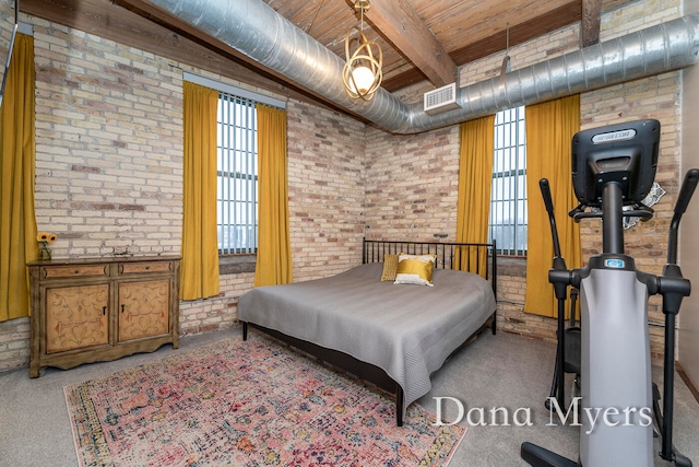 bedroom featuring carpet flooring, multiple windows, beamed ceiling, and brick wall