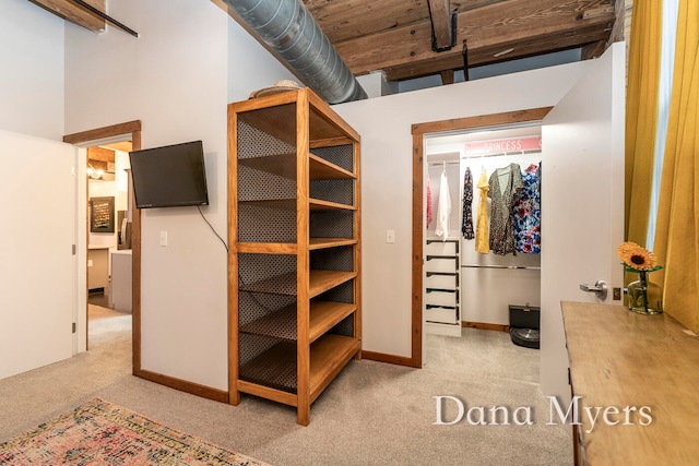 spacious closet featuring light carpet and a high ceiling