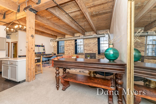 misc room featuring beam ceiling, wood ceiling, and brick wall