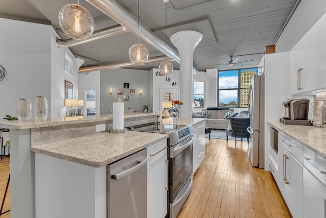 kitchen featuring pendant lighting, light hardwood / wood-style flooring, ceiling fan, white cabinetry, and stainless steel appliances