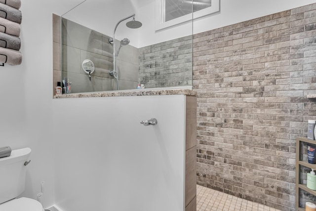 bathroom featuring toilet and tiled shower