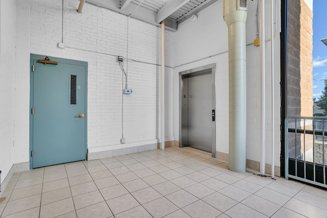 interior space with elevator and light tile patterned flooring