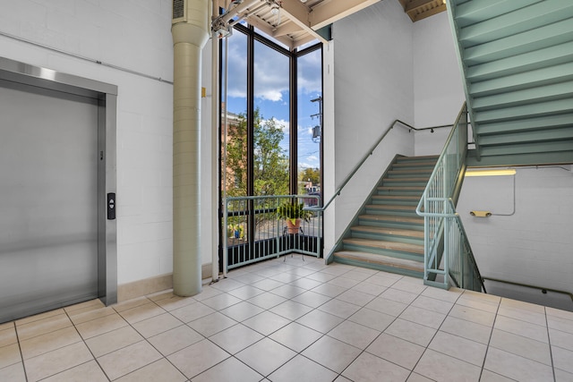 entrance foyer with light tile patterned floors and elevator