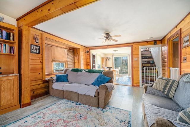 living room with ceiling fan and wooden walls