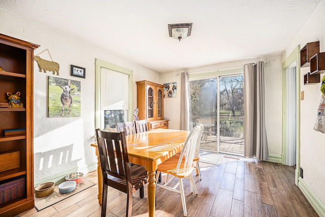 dining space with wood-type flooring